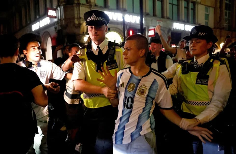 Police Escort Argentina Fan To Safety As He Is Surrounded By England Supporters In Piccadilly Circus